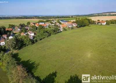Letecký pohled na developerský pozemek s projektem výstavby čtyř rodinných domů a obec Těšínky u Kolína.