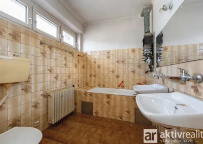Koupelna s vanou a dvojitým umyvadlem v původním stavu vhodná k rekonstrukci