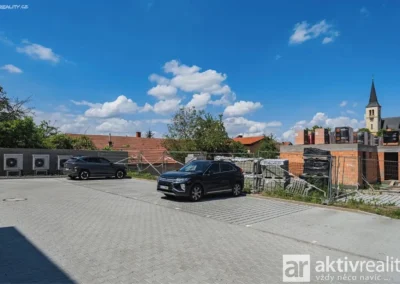 Parkovací stání před novostavbami rodinných domů v obci Ovčáry u Kolína.