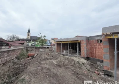 Pohled na pozemek za rodinným domem ve výstavbě v obci Ovčáry u Kolína.